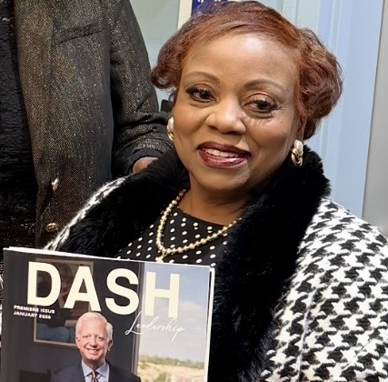 A guest smiling while holding the DASH Leadership premiere issue magazine